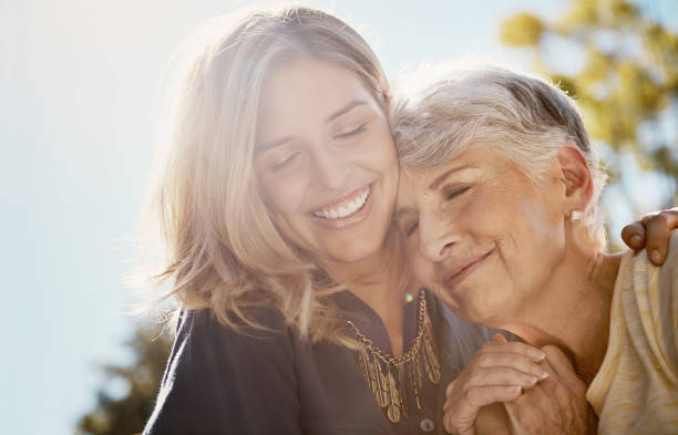 Mother and daughter smiling outdoors representing 24/7 senior monitoring service for families without 24/7 staffing.